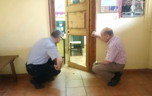 D. Francisco Lledías y Fernando García comprueban los daños en la puerta de acceso al despacho de Cáritas.