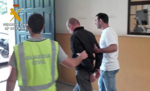 Uno de los detenidos en la operación es llevado por la Guardia Civil.