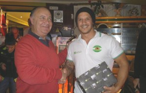 José López entrega un regalo al capitán del Bathco Independiente.